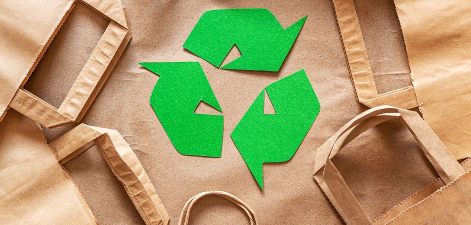 Recycle logo among brown paper bags