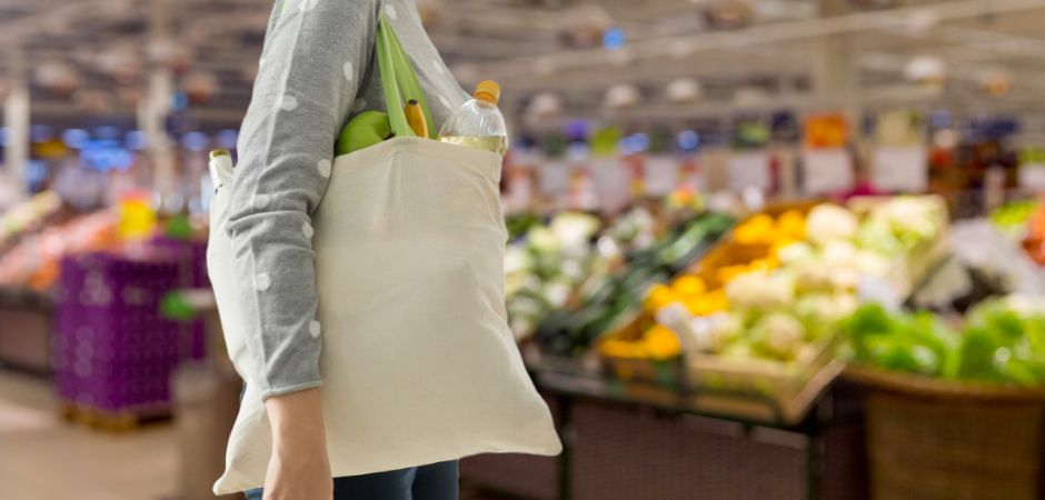 Woman holding cotton carrier bag in the supermarket. 